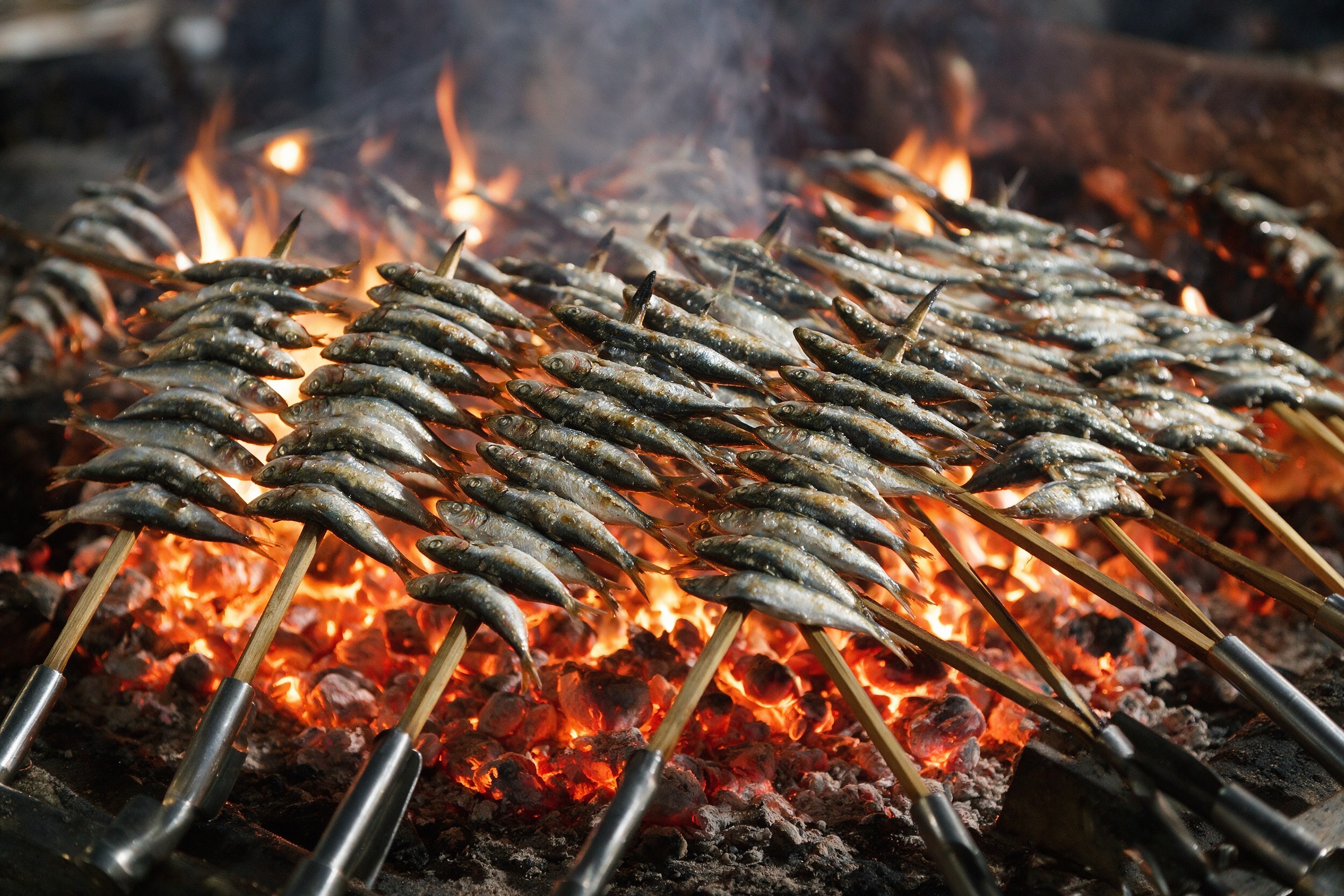 Espetos de sardinas asándose sobre brasas de caña en la playa